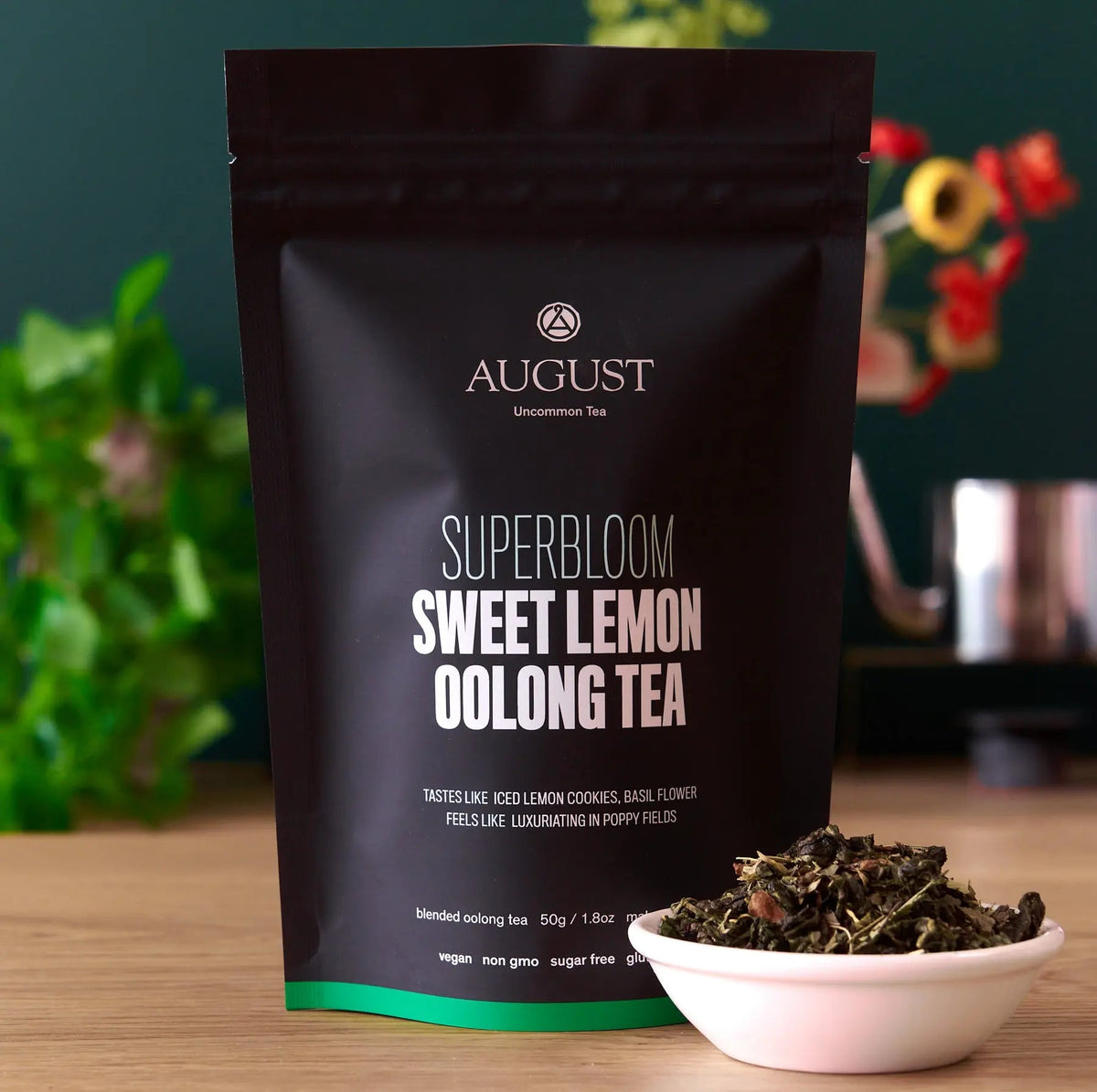 Superbloom sweet lemon oolong tea pouch beside a bowl of loose tea leaves