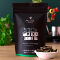Superbloom sweet lemon oolong tea pouch beside a bowl of loose tea leaves