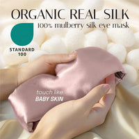 Pink mulberry silk sleep mask held in a hand