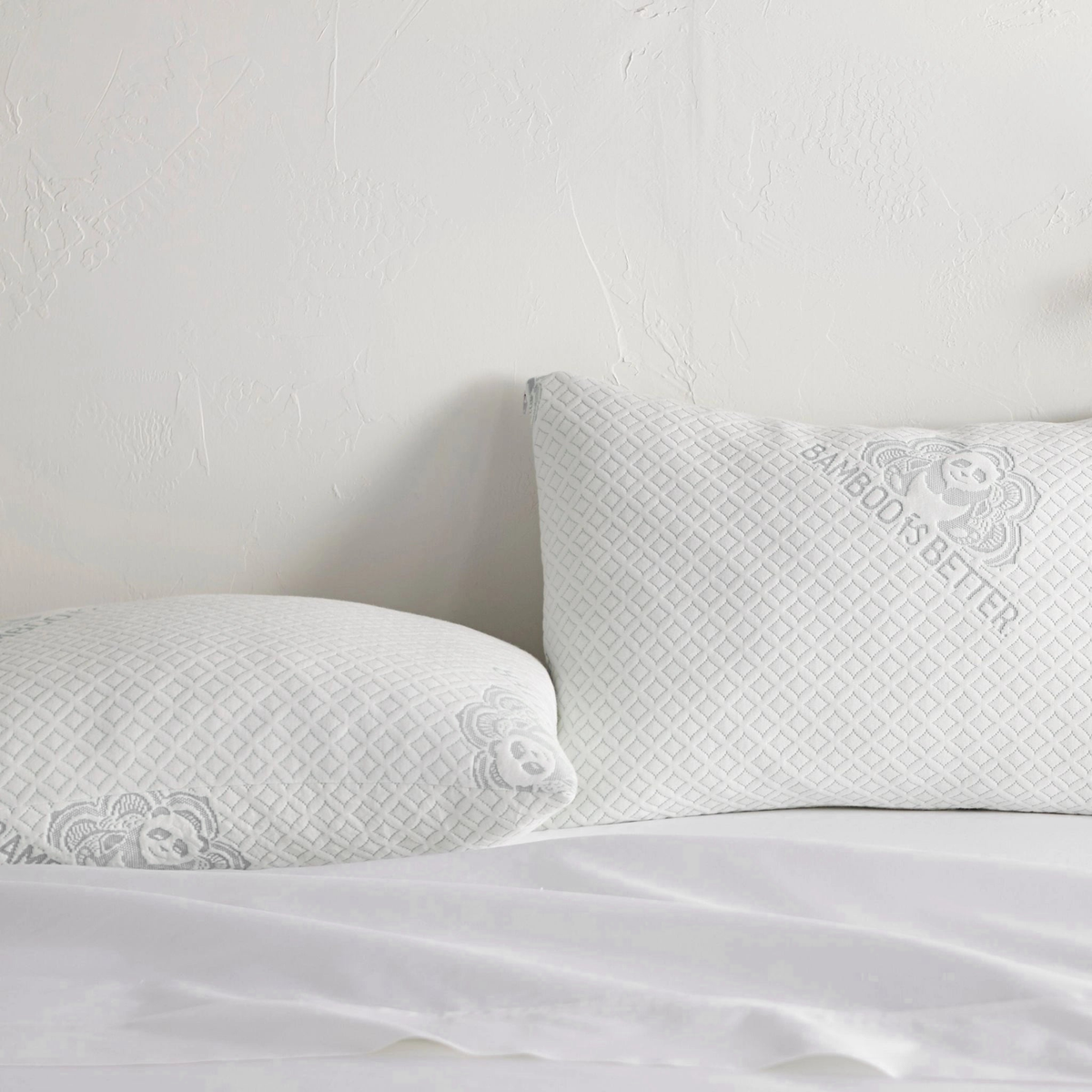 Adjustable bamboo cooling pillow pair styled on a bed