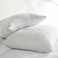 Two adjustable bamboo cooling pillows stacked on a white bed, one showing the zipper